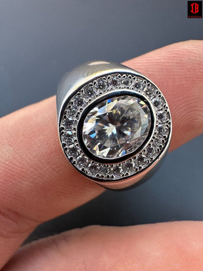 A hand showcasing an oval cut Moissanite ring with a sparkling Oval Moissanite diamond in the center Surrounded by  little Round Moissanite Stones