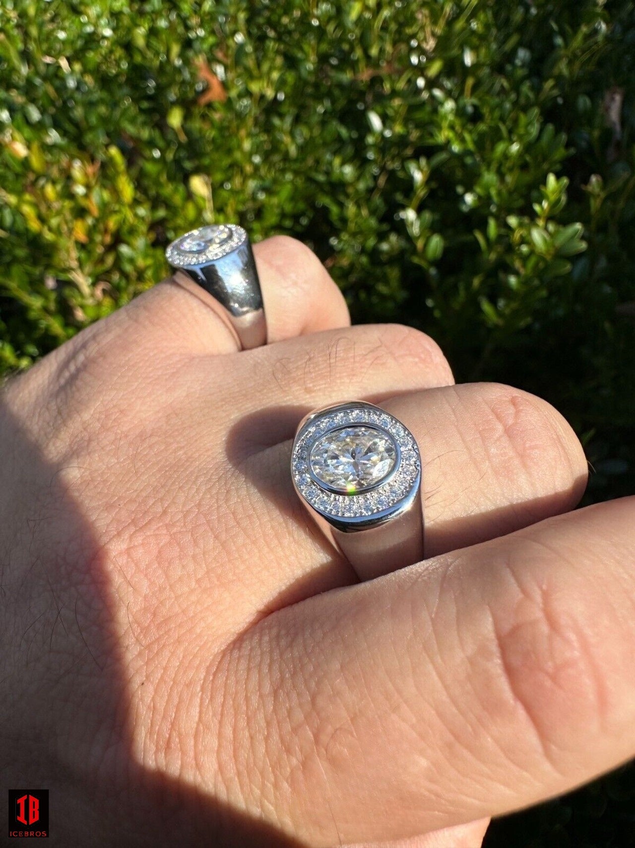 Two exquisite 14k White Gold Moissanite rings flawlessly captured in a man's hand.