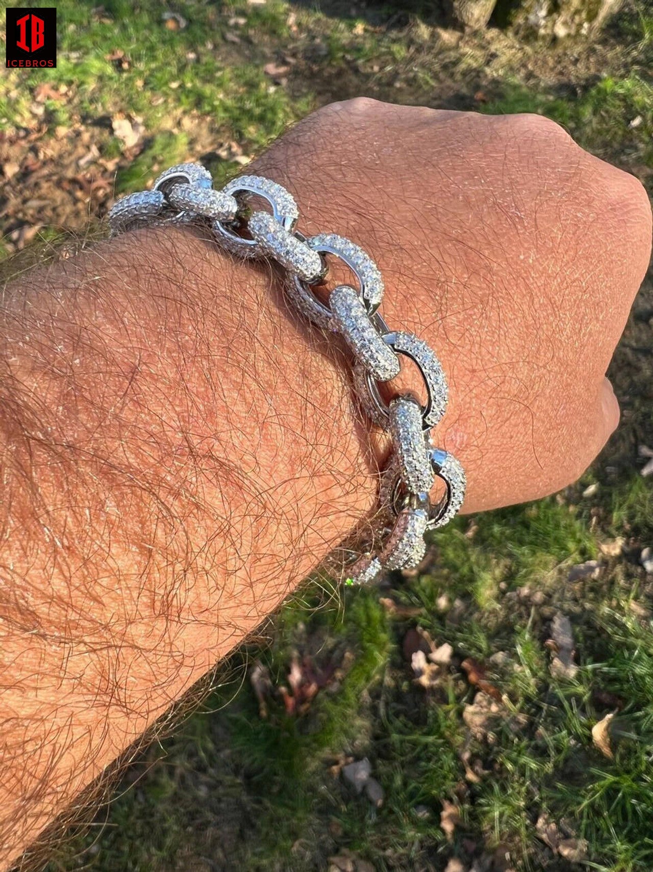 A gentleman adorns his arm with a resplendent moissanite bracelet, gleaming in silver radiance.