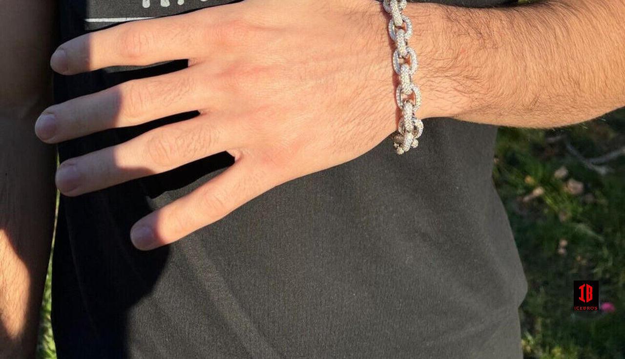 A man wearing a stylish White Gold Rolo Link bracelet on his hand, adding a touch of elegance to his attire.