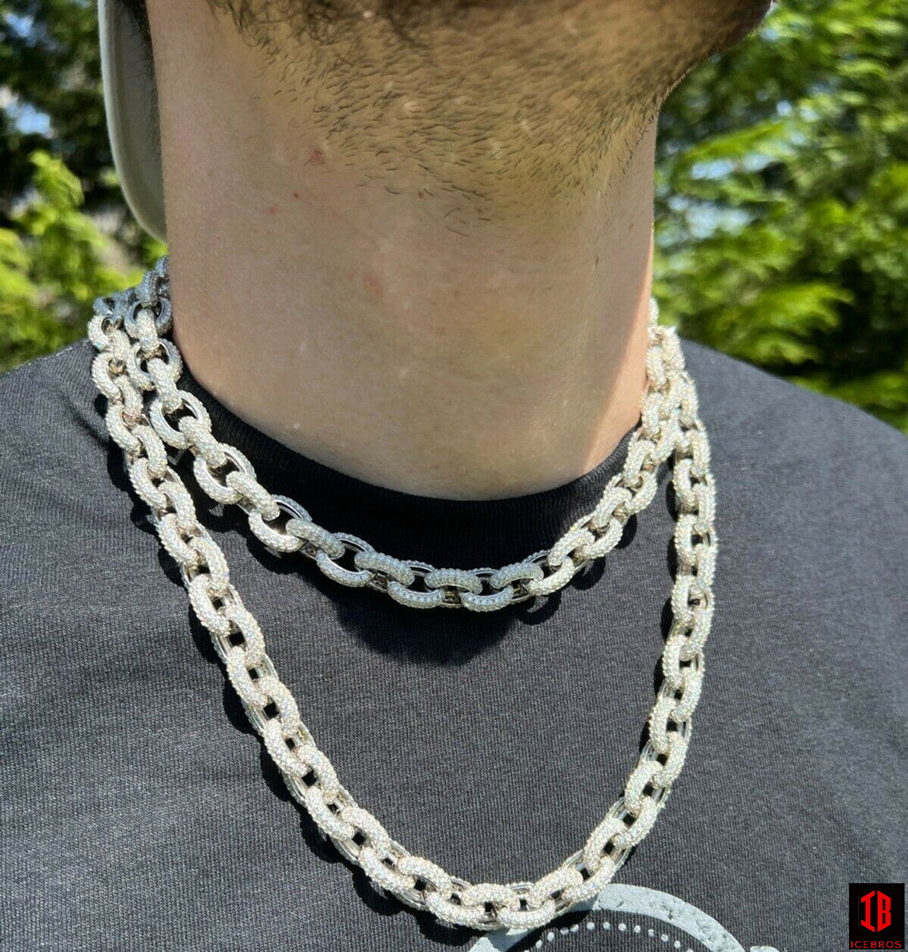 A stylish man in a black shirt accessorized with a 925 Sterling  silver chain.