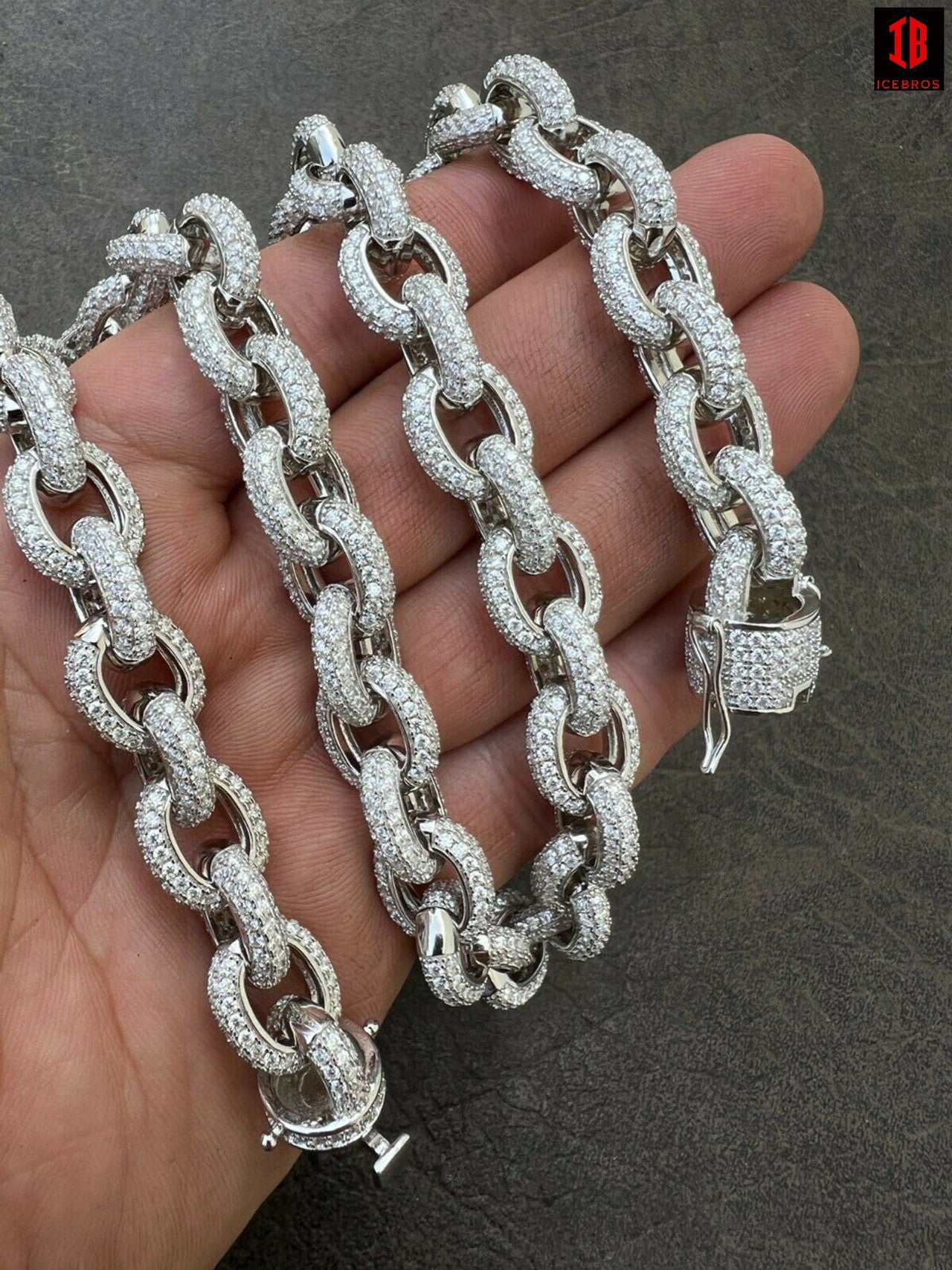 A hand grasping a diamond Rolo link chain, showcasing elegance and luxury.