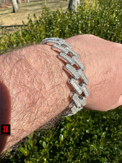 A gentleman adorns his wrist with a gleaming silver bracelet, exuding elegance and sophistication.