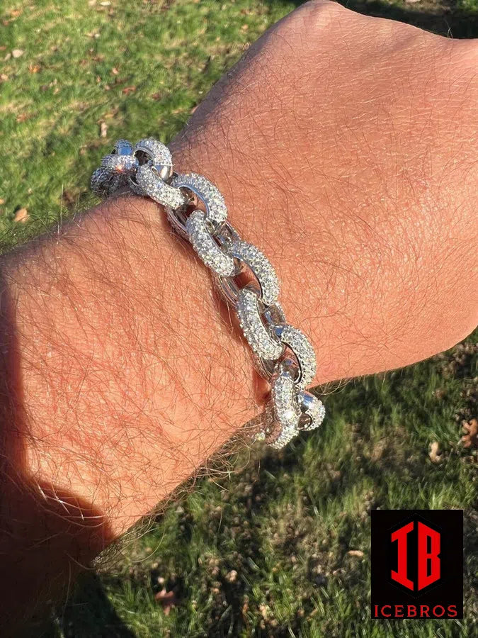 A man's wrist adorned with a sleek sterling silver Rolo Link chain bracelet, adding a touch of sophistication to his outfit.