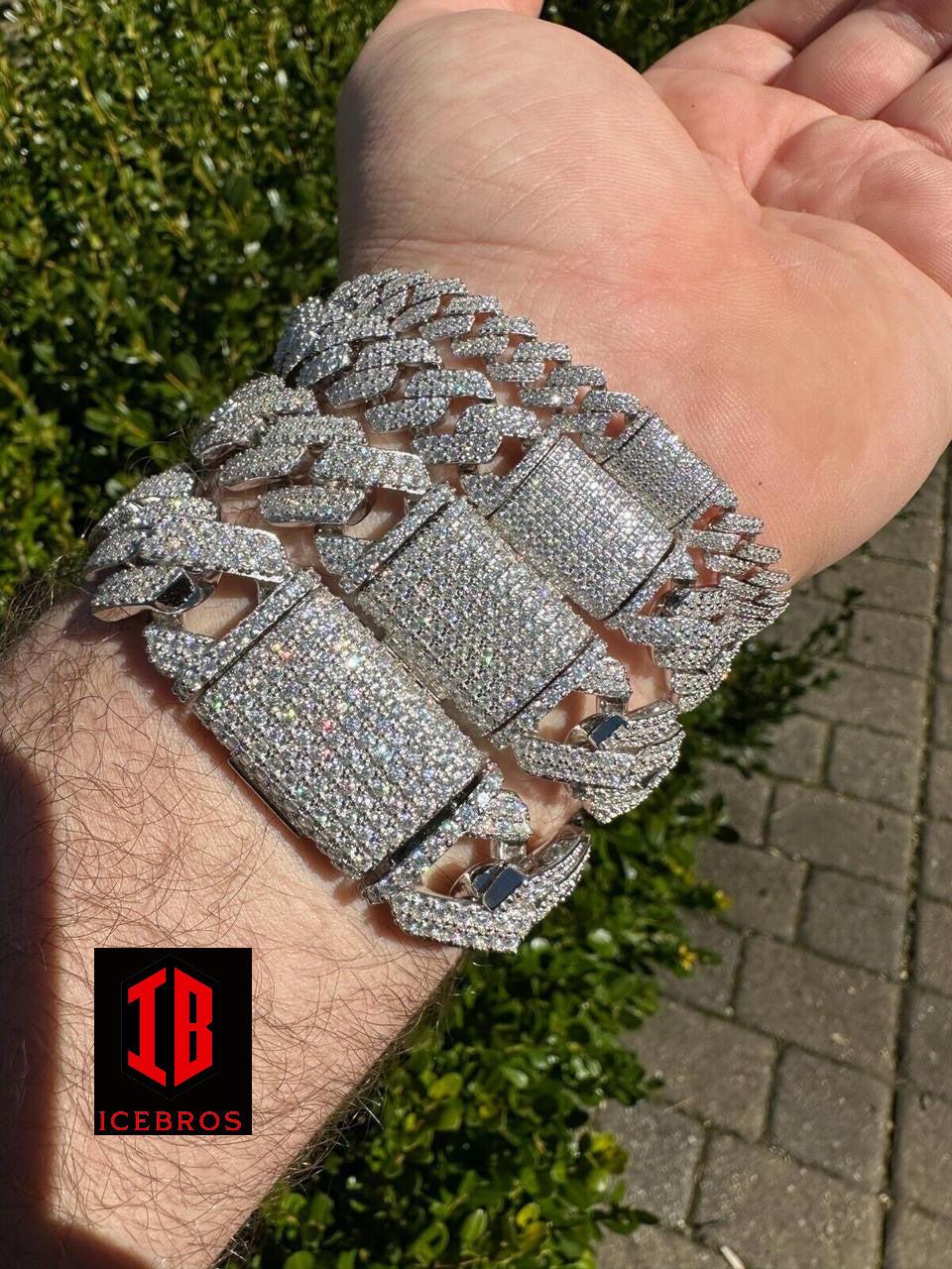 Close-up view of a male hand model wearing a stylish 14k White Gold VVS Moissanite Miami Cuban Link Bracelet in various sizes.