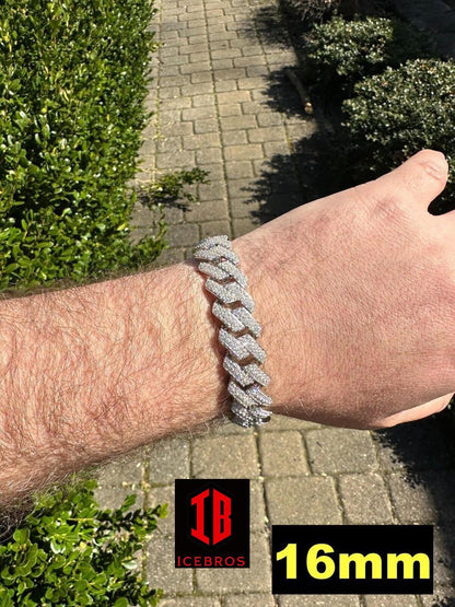 Close-up view of a men's hand model wearing a  White Gold Two-Tone Miami Cuban Link Bracelet. The bracelet features intricate links with alternating  white gold segments, creating a striking contrast. It rests comfortably on the model's wrist, showcasing its elegant and masculine design