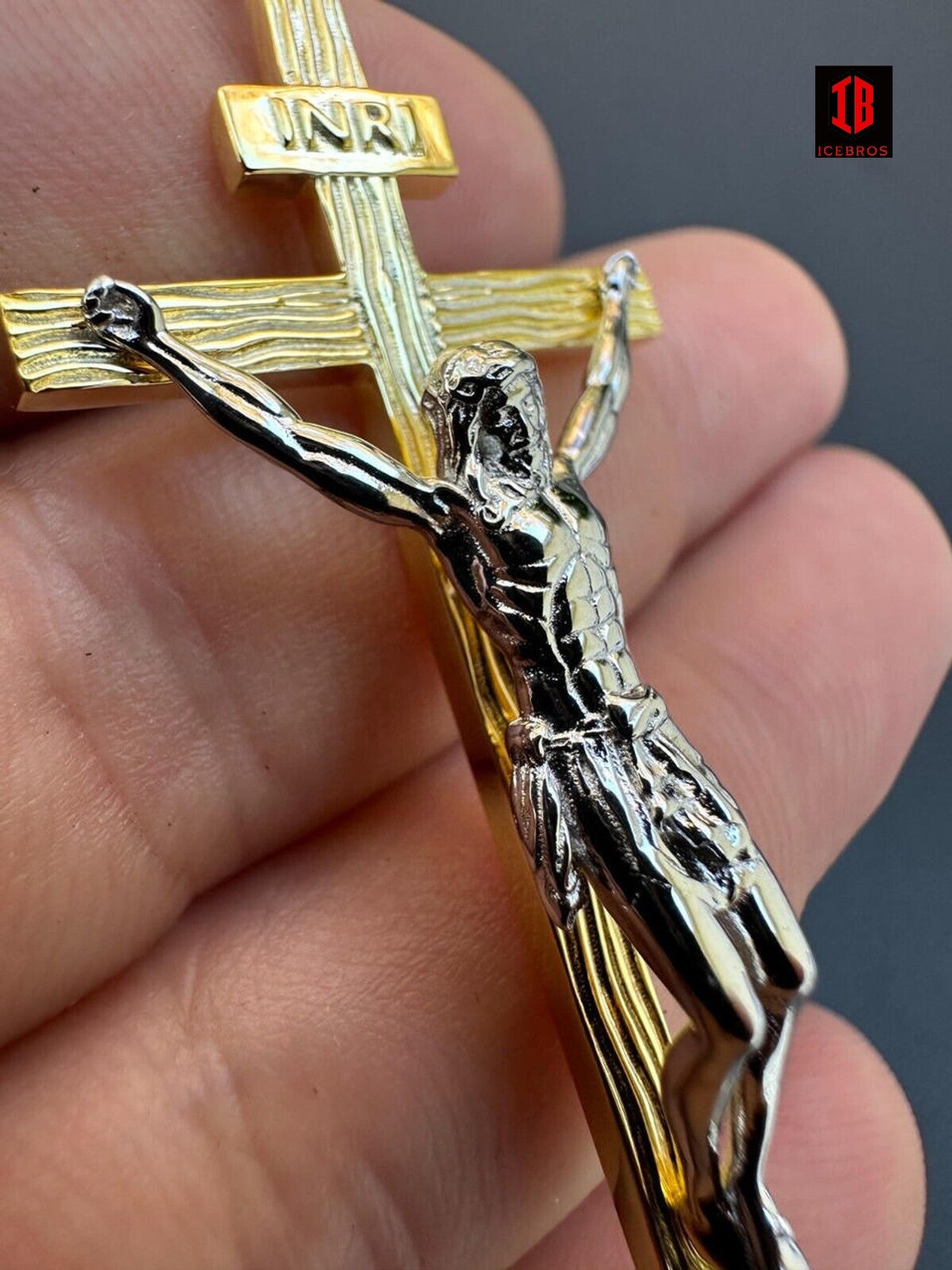 A person holding a 14k gold and White Gold crucifix.