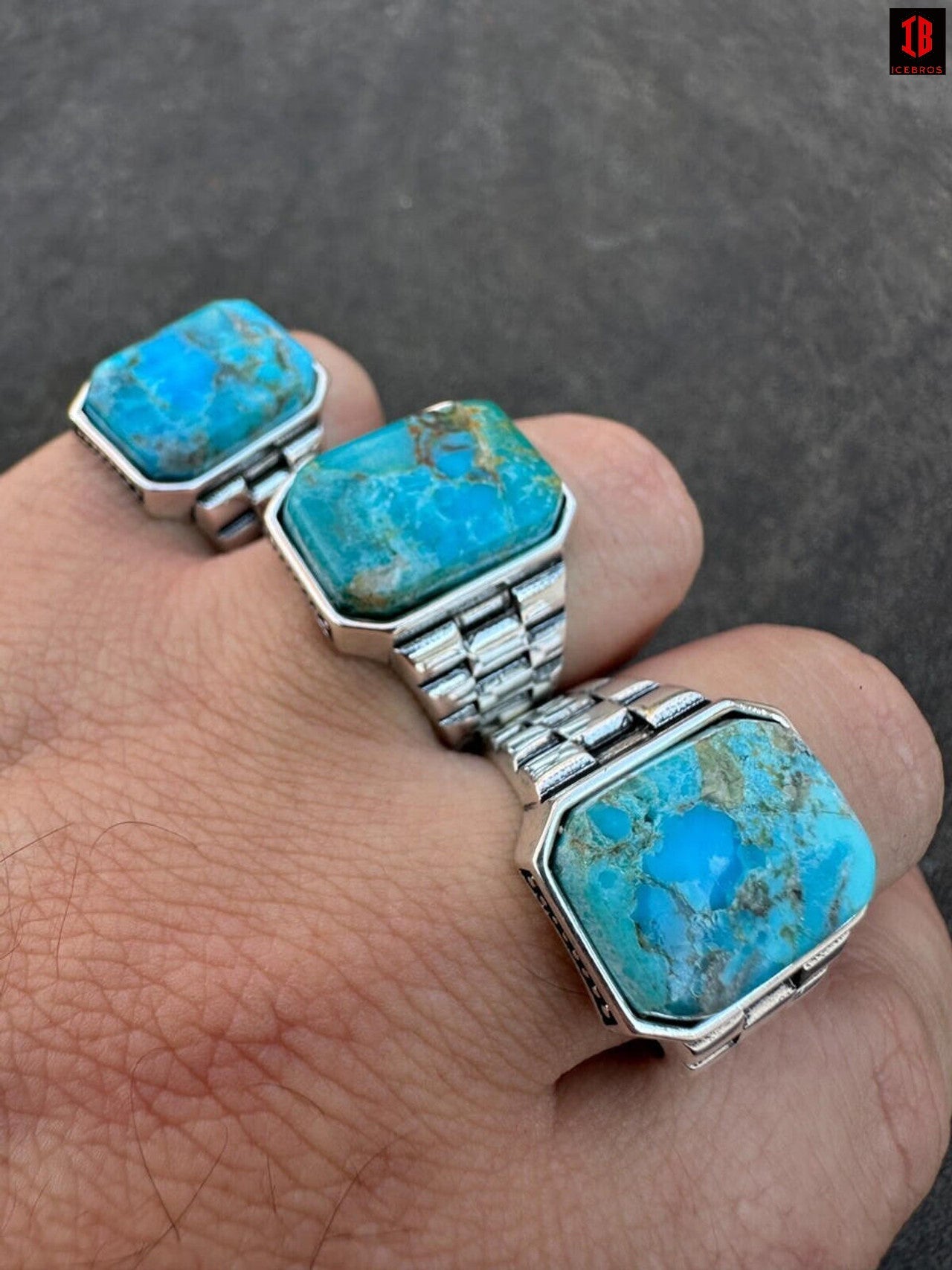 A hand showcasing three rings adorned with square cut bule turquoise stones.