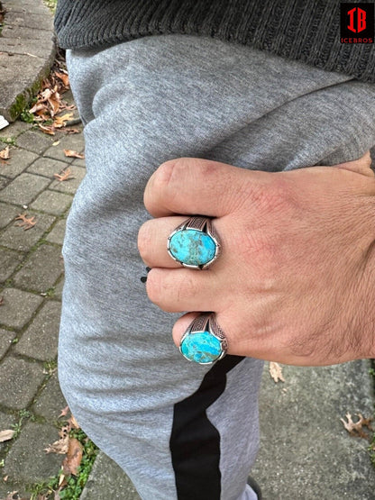 A man wearing blue and white rings on his fingers.