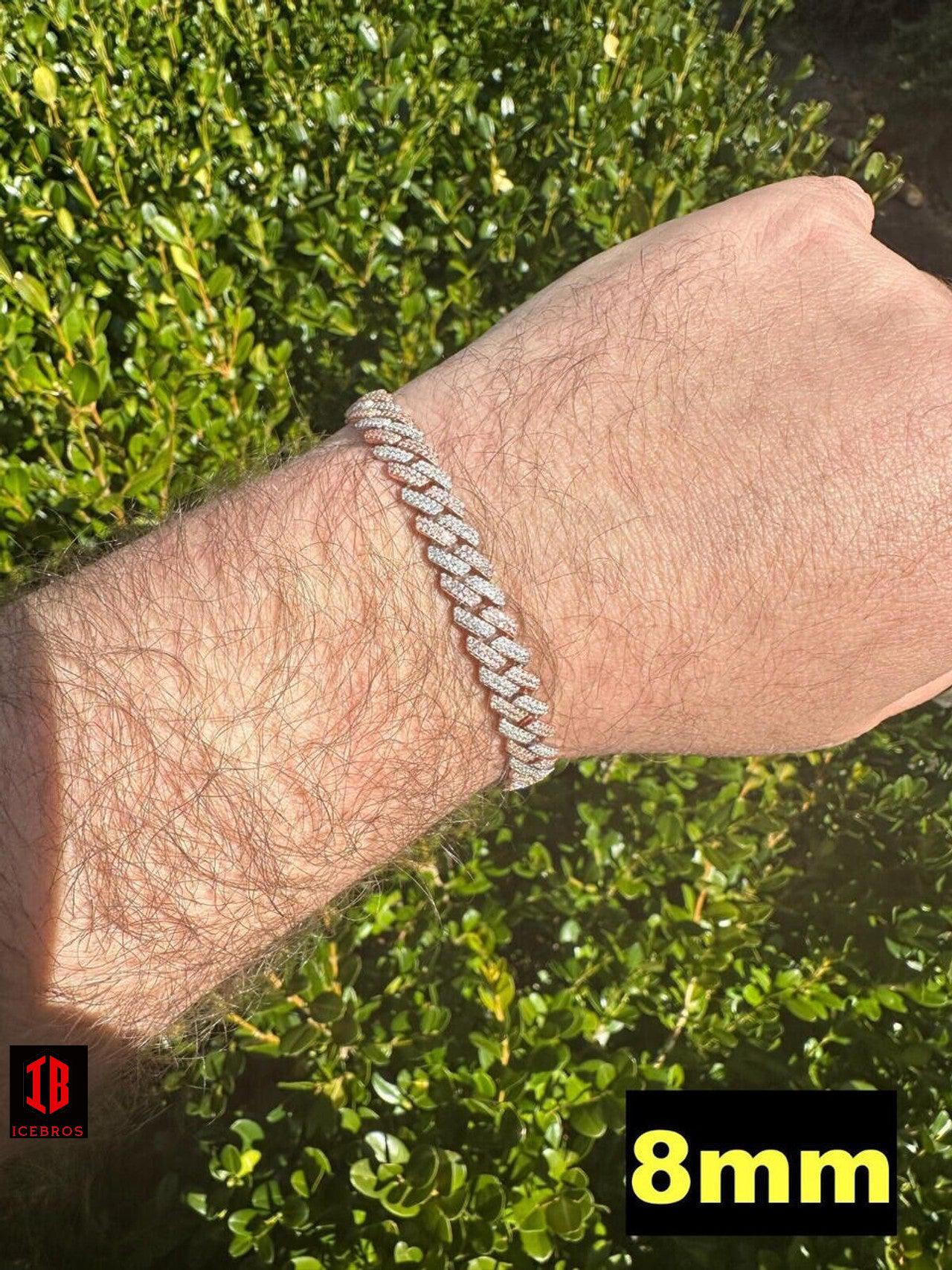 Close-up view of a men's hand model wearing a 14k Rose & White Gold Two-Tone Miami Cuban Link Bracelet. The bracelet features intricate links with alternating rose and white gold segments, creating a striking contrast. It rests comfortably on the model's wrist, showcasing its elegant and masculine design