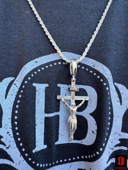 A chain with a white gold  crucifix pendant, depicting a cross with Jesus.
